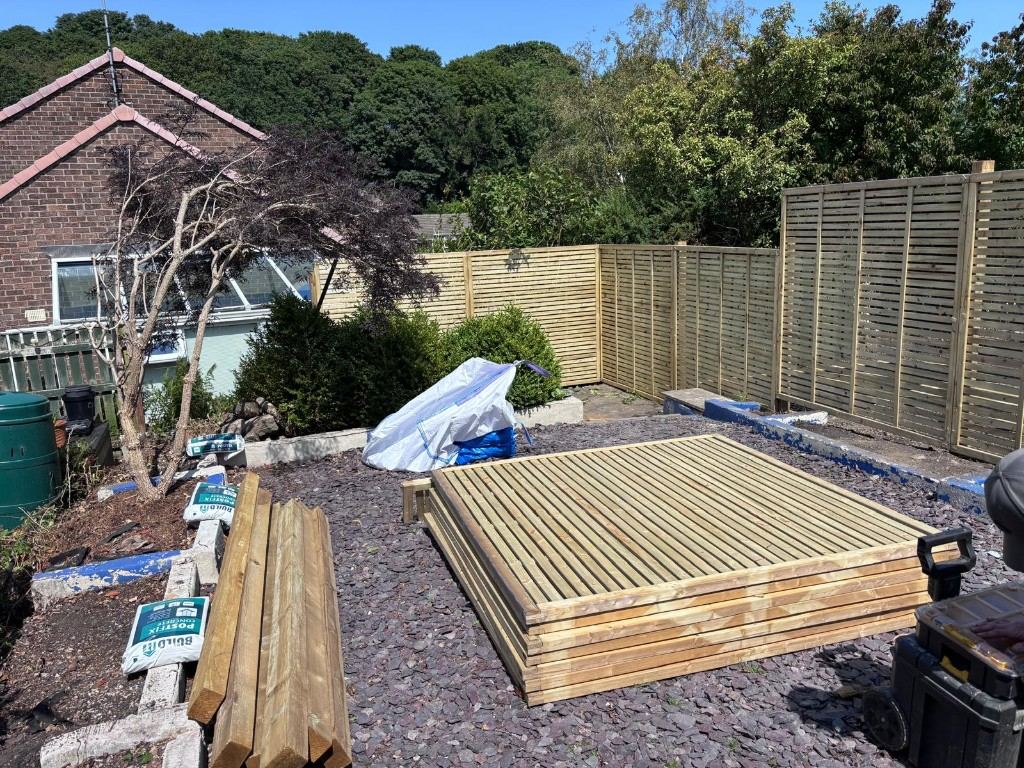 Before: new slatted fence panels and posts stacked ready to fit