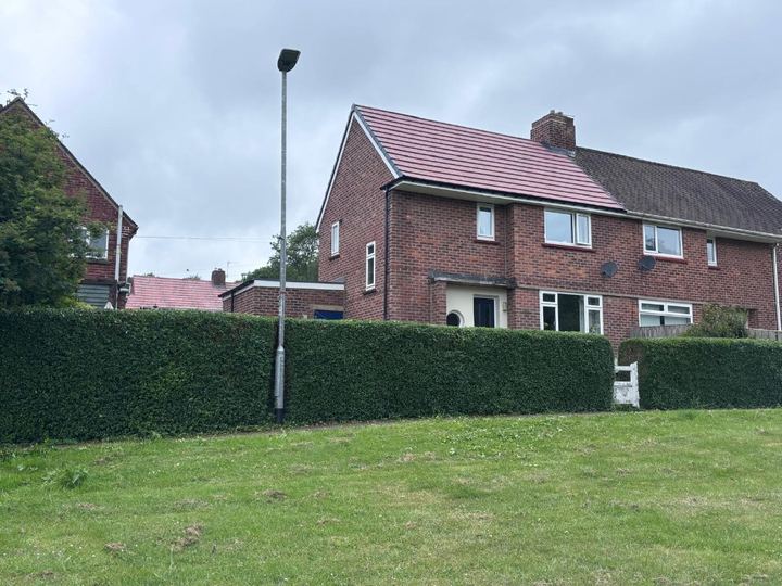 Long front hedge trimmed square outside a house