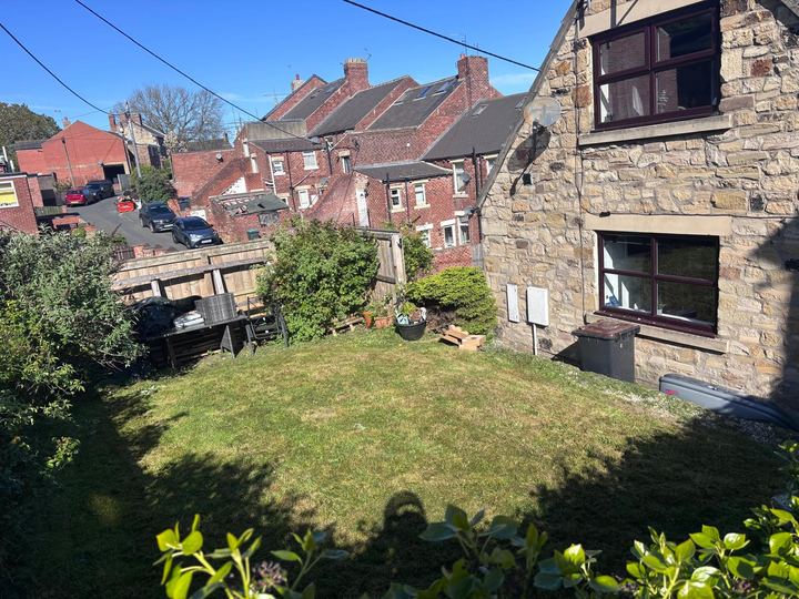 Lawn cut beside a stone cottage